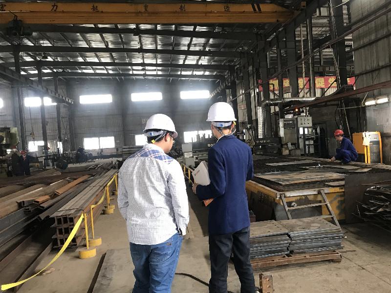 Le client vietnamien, M. Hoàng, visite l'usine pour inspecter les progrès de la production de structures en acier et organiser l'expédition pour le projet de Hanoï